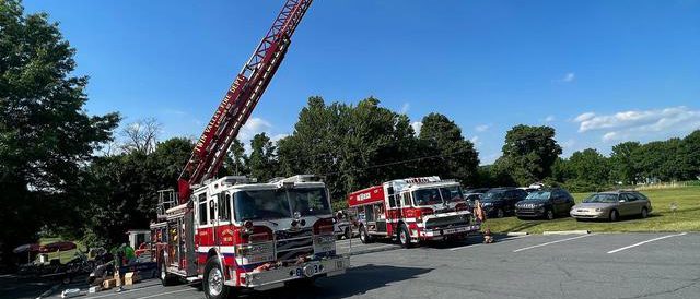 The ladder on a fire truck extended and displaying the American flag