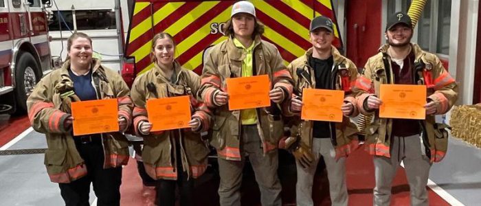 Fire department crew members holding certificates