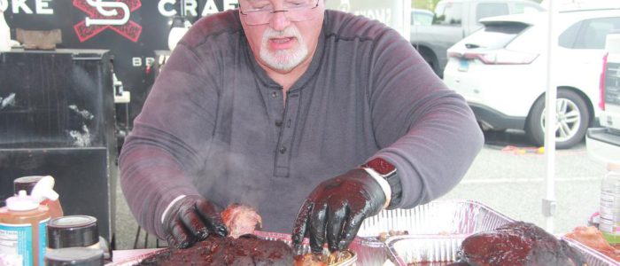 A man putting his cooked meat into an aluminum pan