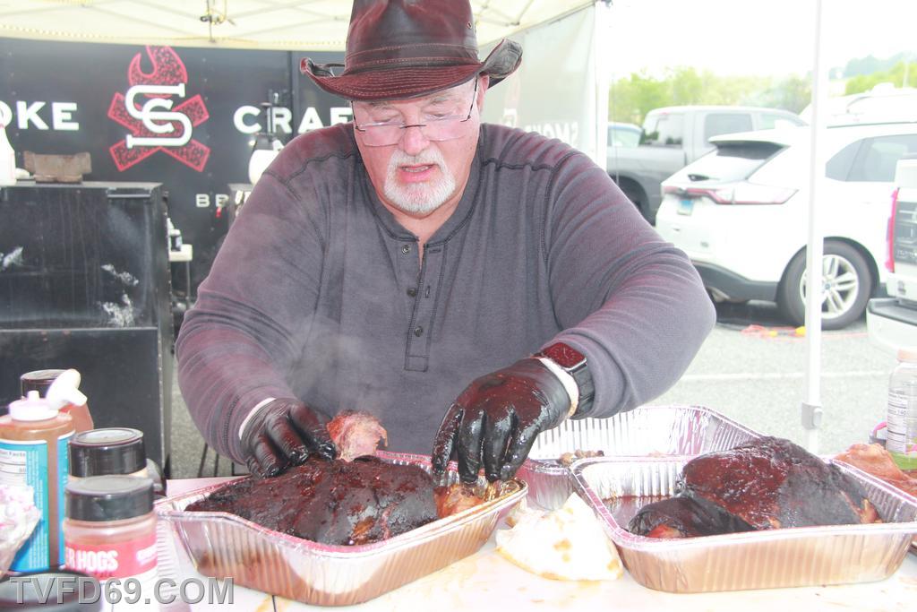 A man putting his cooked meat into an aluminum pan