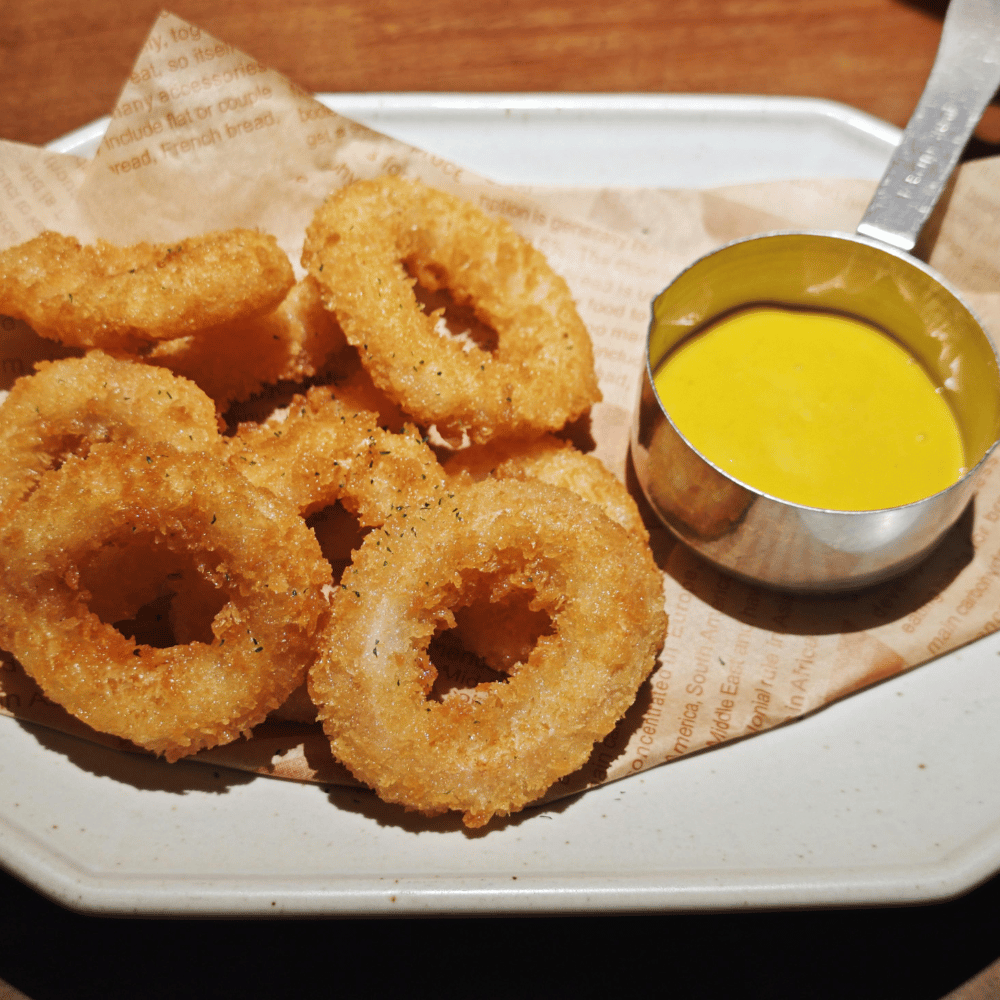 Onion rings and a small cup of sauce